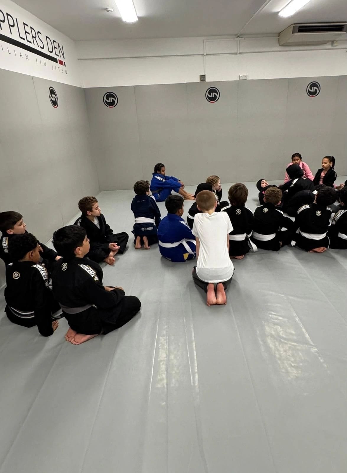 Kids BJJ students listening to their coach